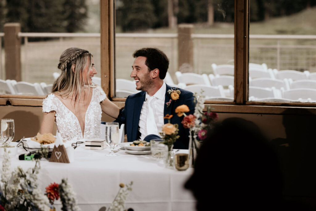 bride and groom eat dinner during wedding reception at colorado ski mountain.
