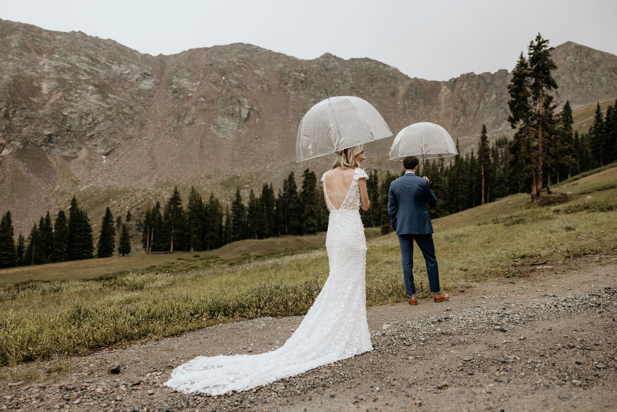 bride and groom stand at base of arapahoe basin during first look at ski wedding.