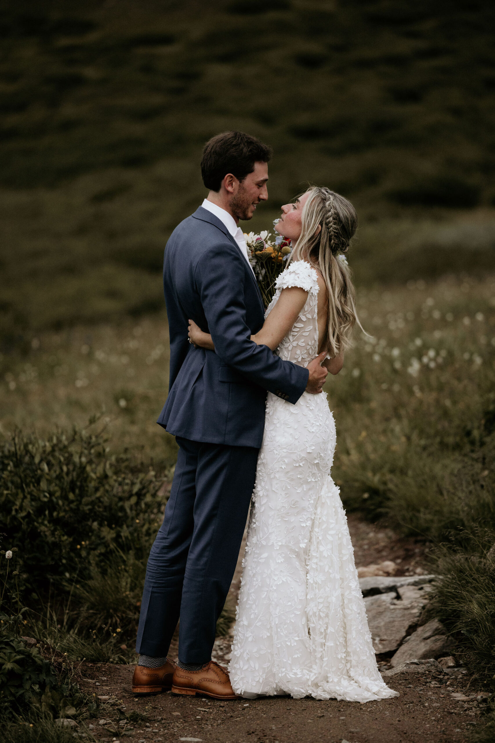 bride and groom embrace during ski mountain wedding at black mountain lodge.