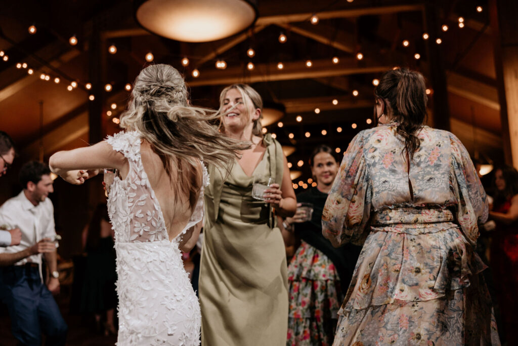 Bride hits the dance floor with guests during colorado summer wedding in the mountains.