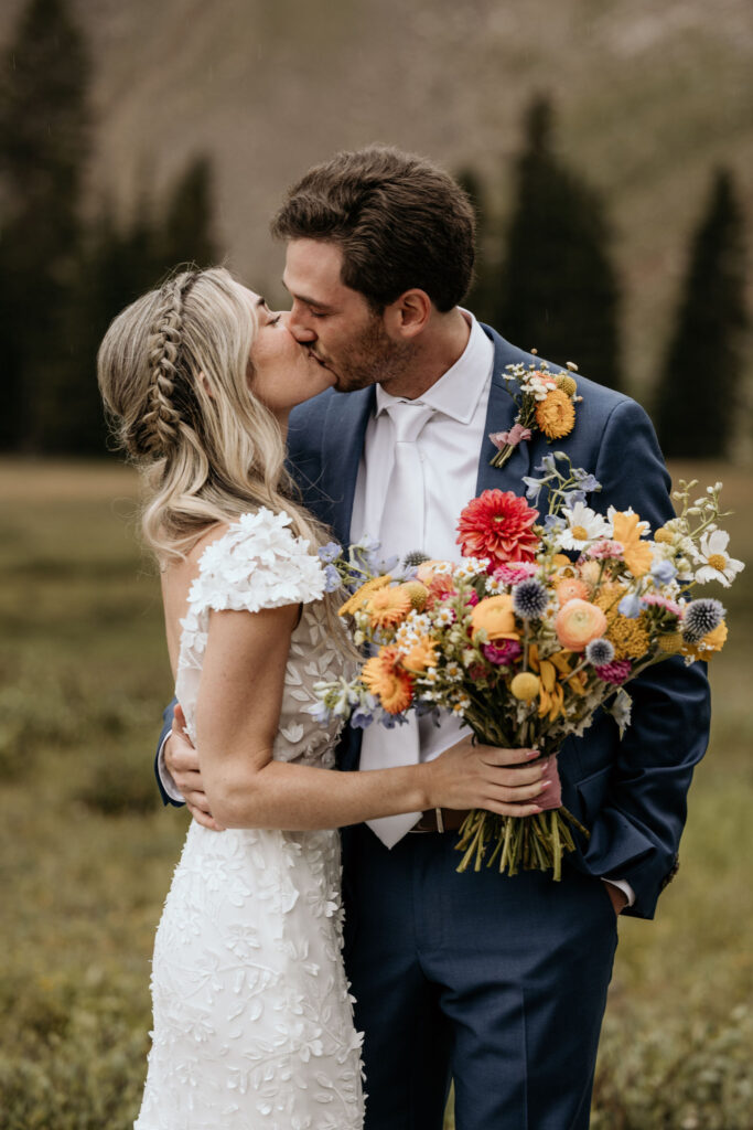bride and groom kiss during their ski mountain wedding in colorado.