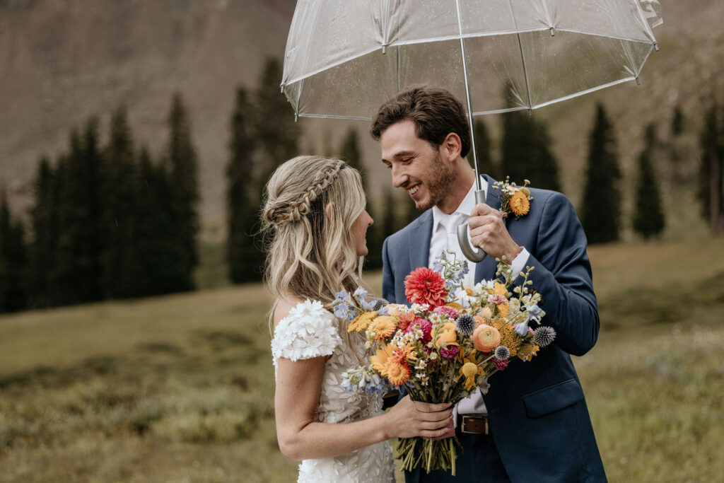 bride and groom look at each other and smile during their ski mountain wedding in colorado.