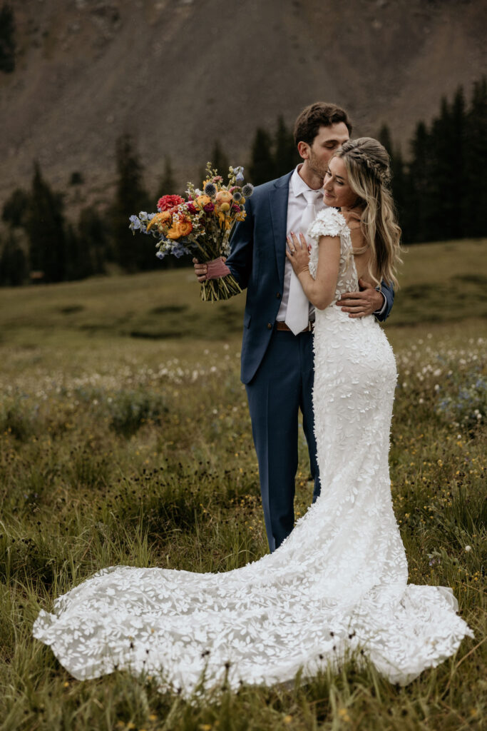 groom kisses bride during their ski mountain wedding in colorado.