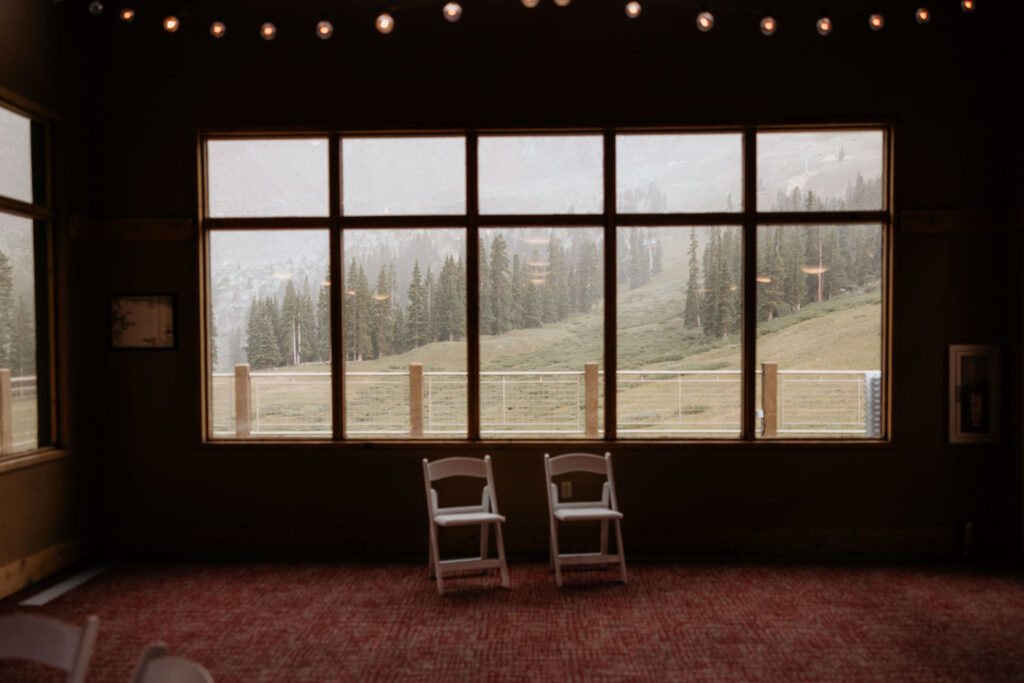 colorado wedding photographer takes a photo of a rainy window with two chairs looking out to the mountians,