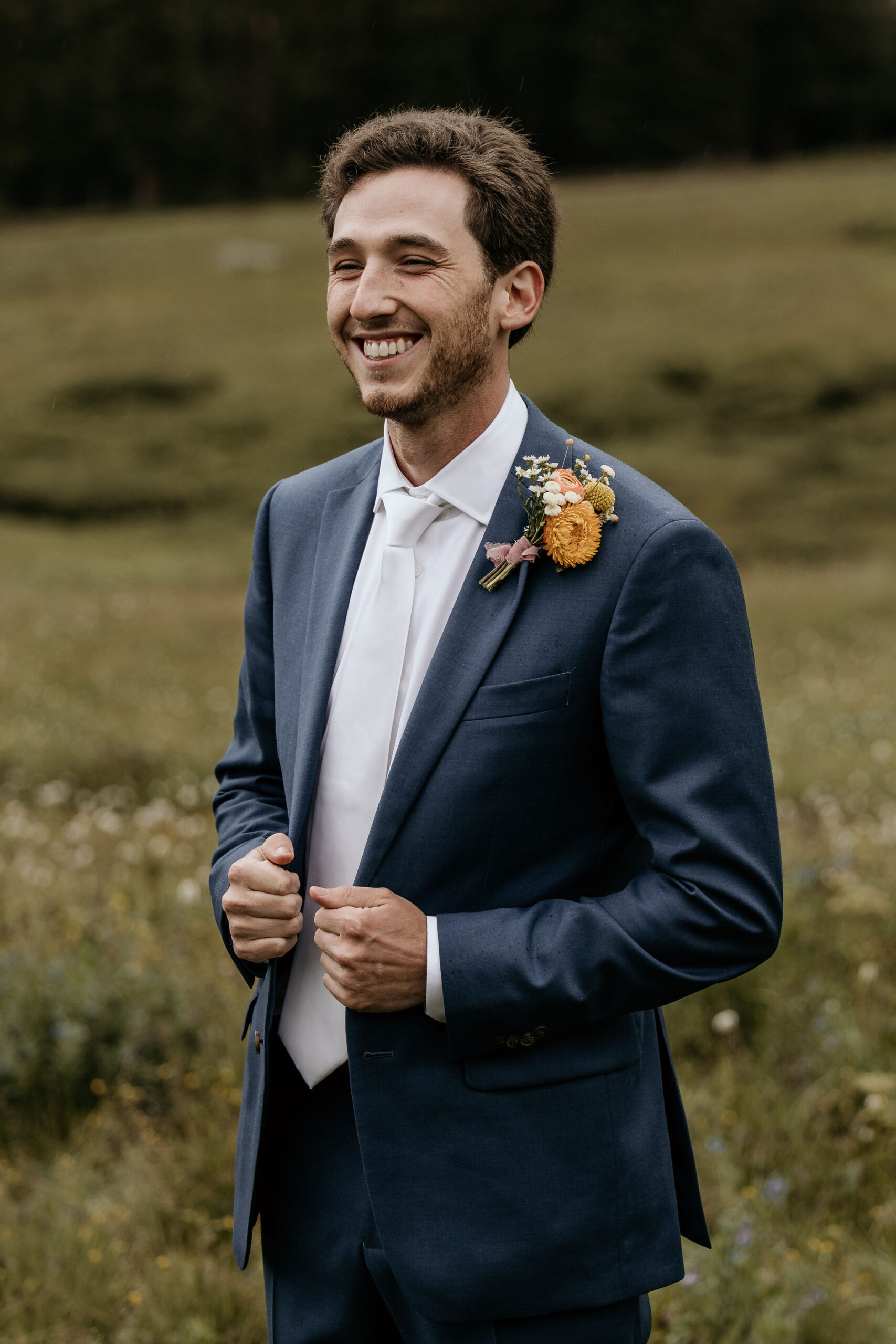 groom poses for colorado micro wedding photographer during ski mountain wedding.