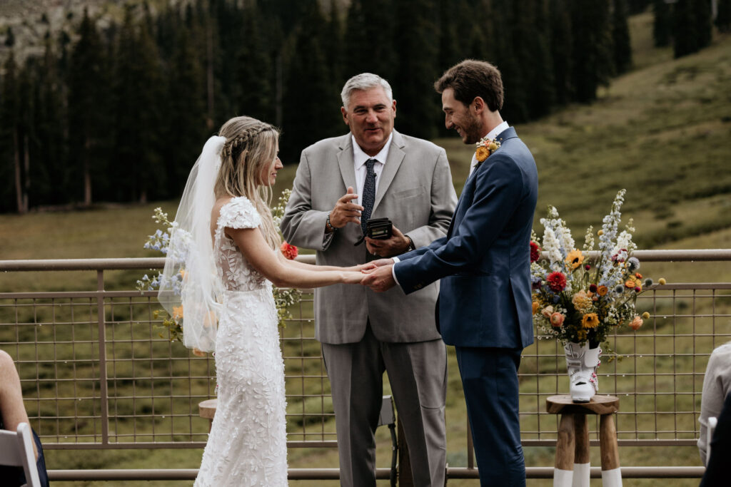 bride and groom stand at their ski mountain wedding ceremony in colorado.