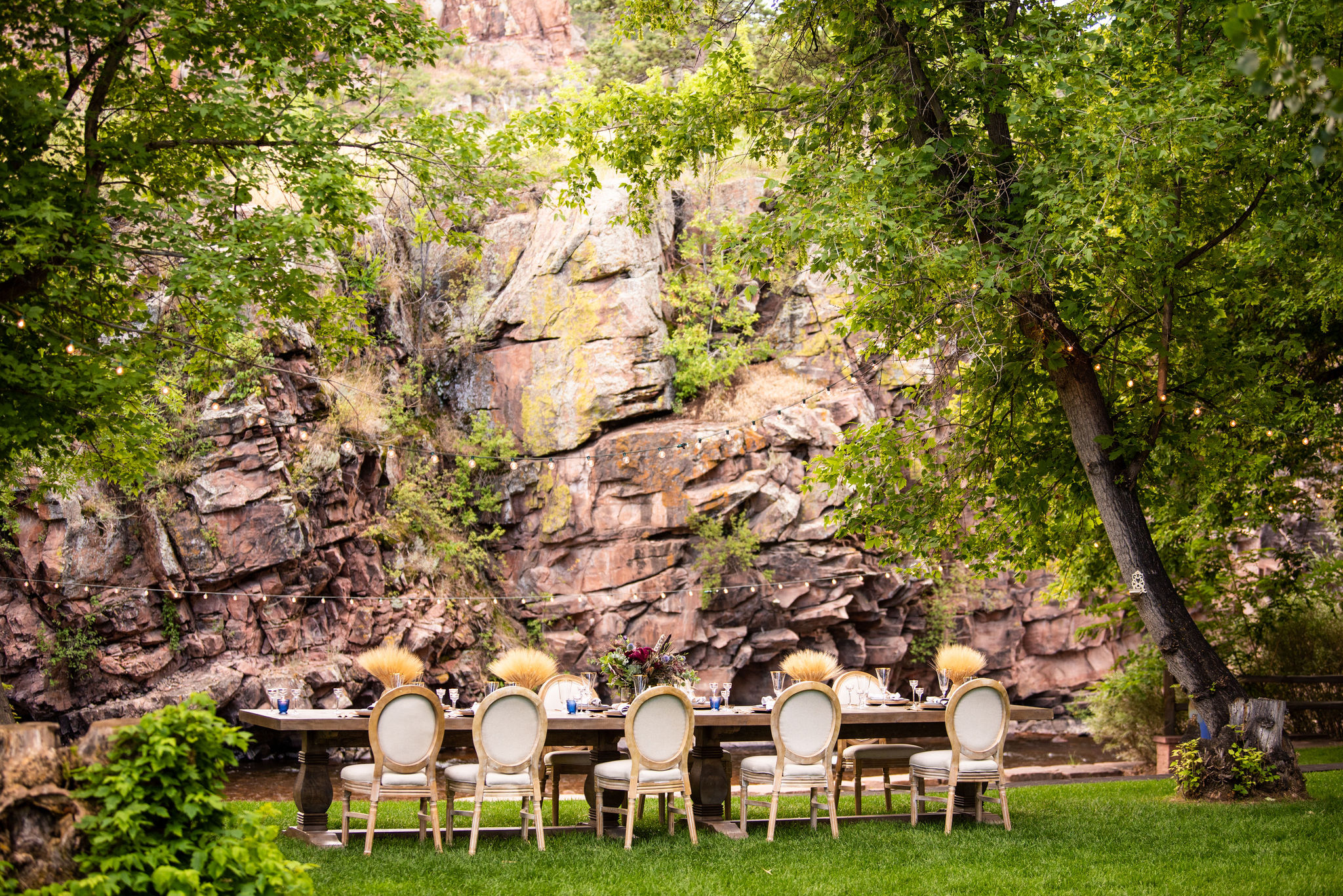 wedding dinner table set up beside rock wall at river bend wedding venue.