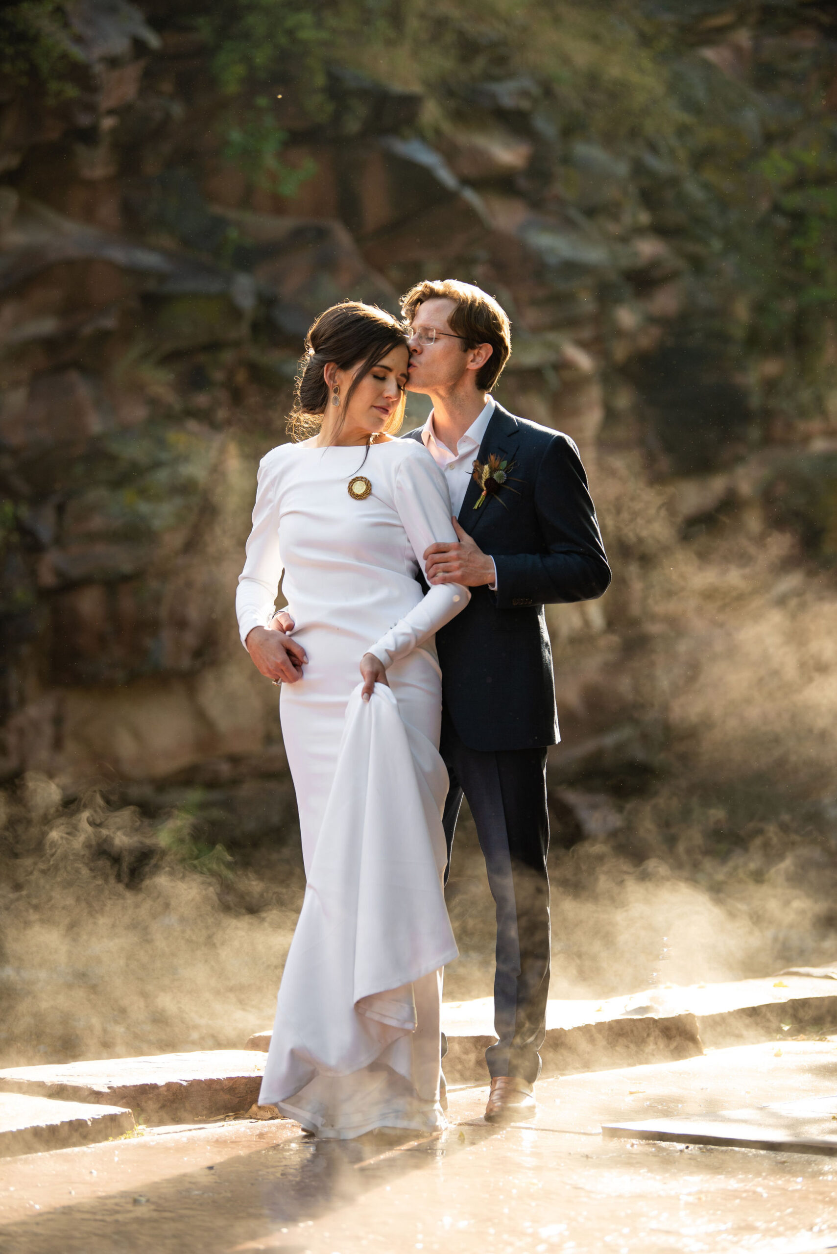 bride and groom stand in rainy steam during colorado micro wedding at river bend venue.