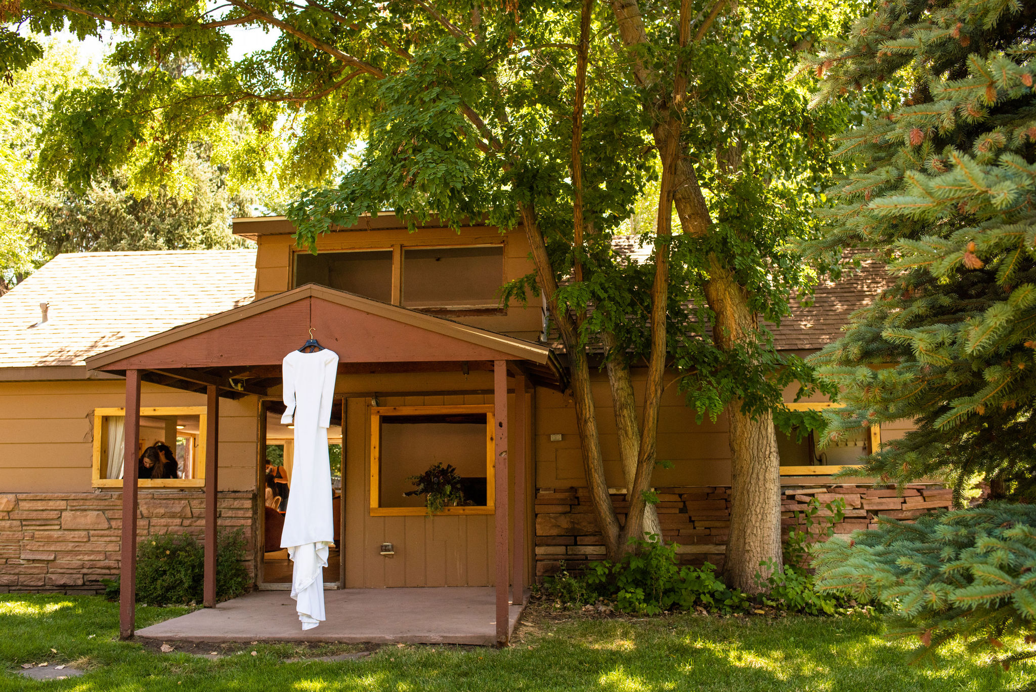 dress hangs outside of cottage at river bend venue for a colorado micro wedding.