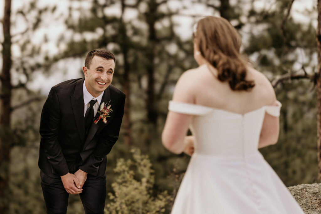 groom smiles at bride during first look at their colorado micro wedding in the mountains.