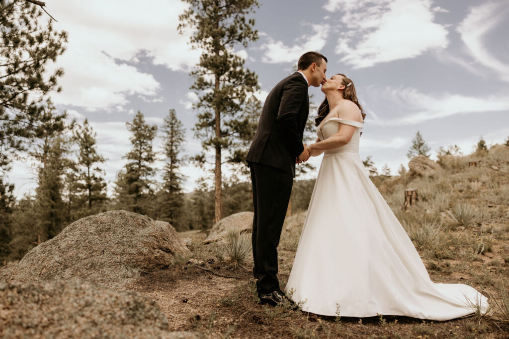 bride and groom kiss outside during mountain micro wedding in colorado.
