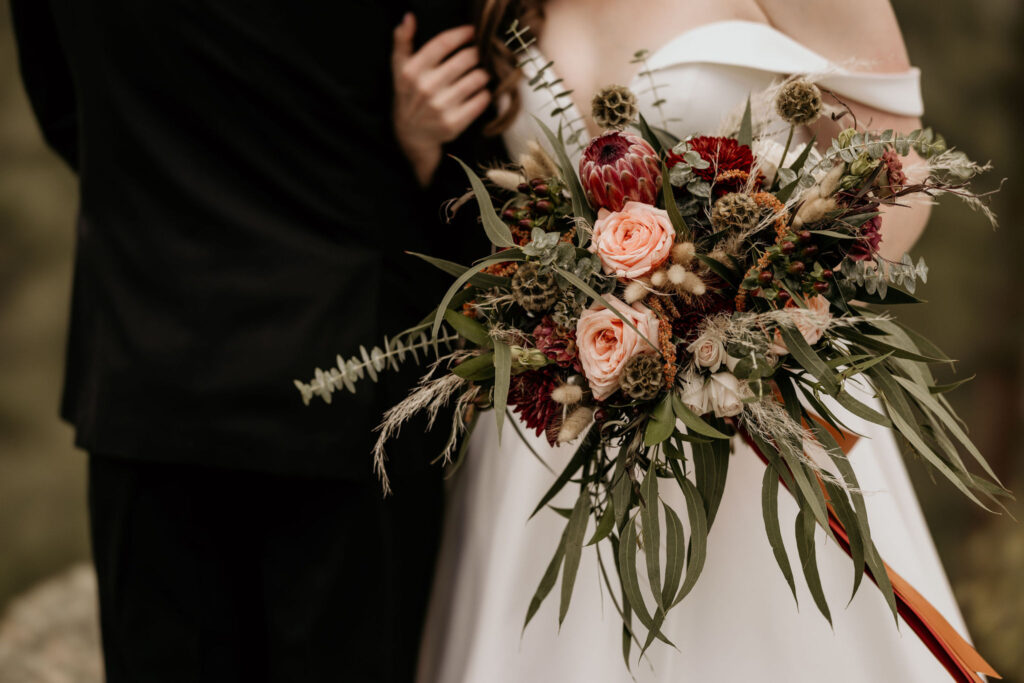 close up image of bride and groom with a floral bouquet during a mountain top micro wedding in colorado.