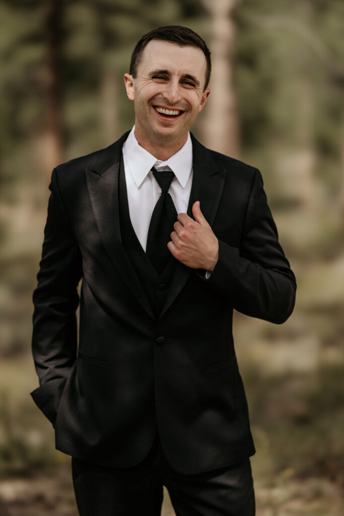 groom smiles and poses during mountain micro wedding in colorado.