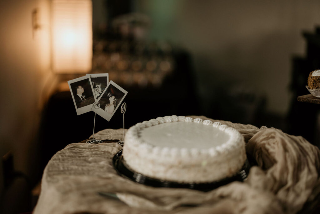 Wedding cake with personal photos behind, set up for a micro wedding reception in the colorado mountains.