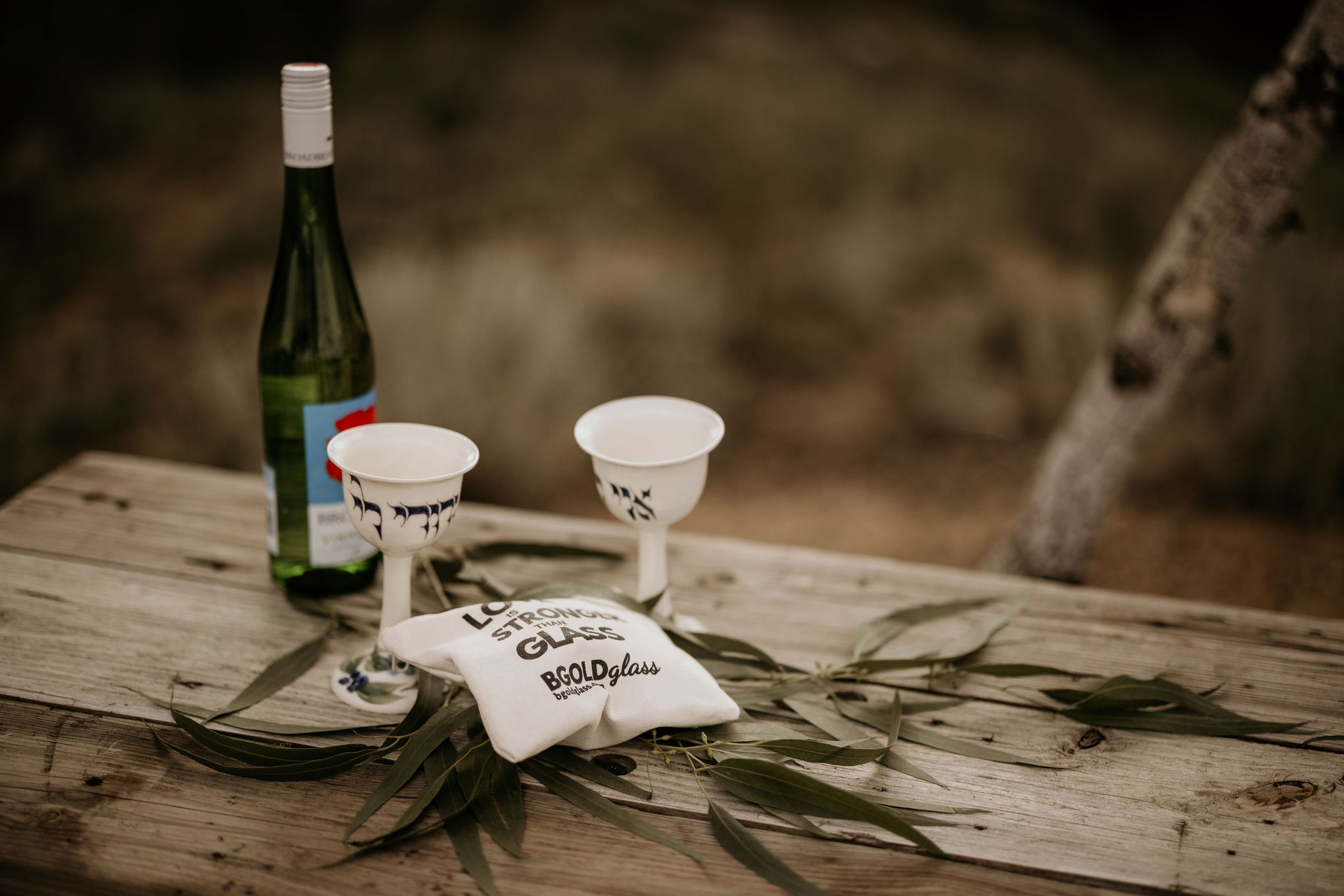 close up of wine and glasses set up for a mountain top wedding ceremony.