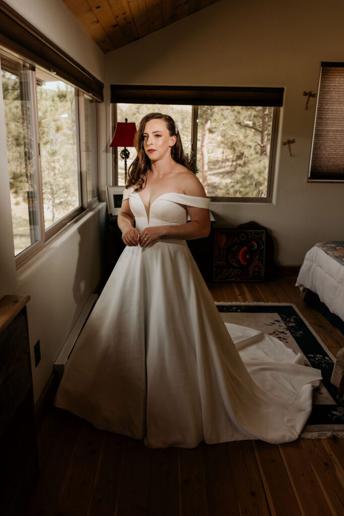 bride stands for portraits during colorado micro wedding in the mountains.