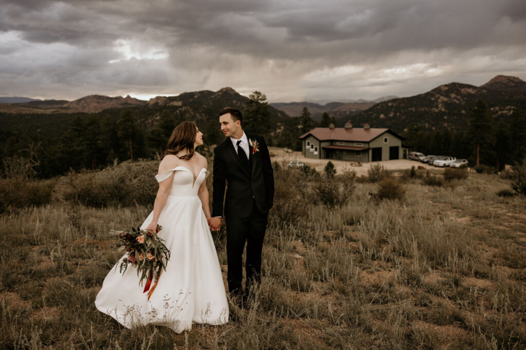 Bride and groom stand with mountains in the background during colorado micro wedding.