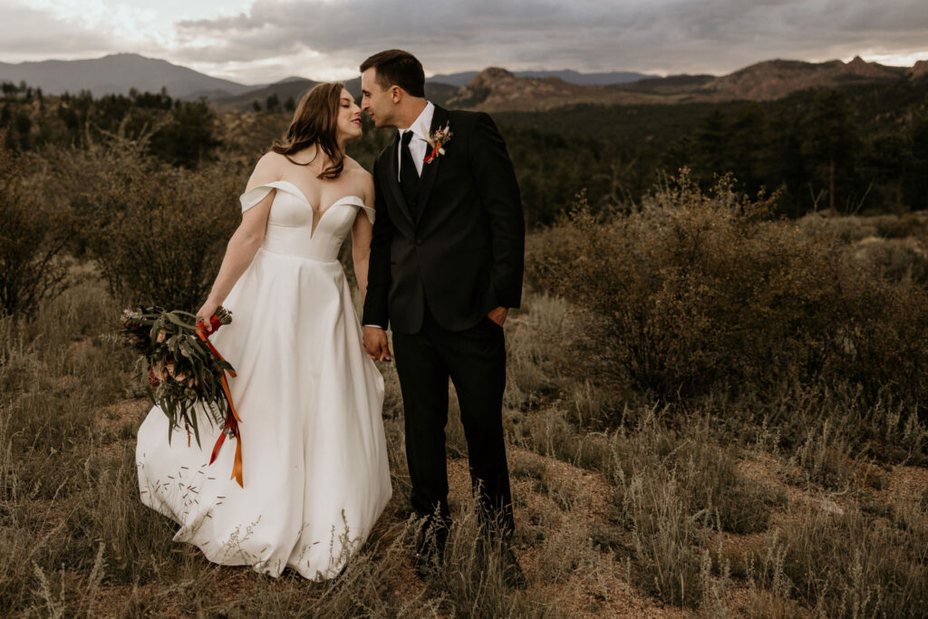Bride and groom kiss with mountains in the background during their micro wedding in colorado.