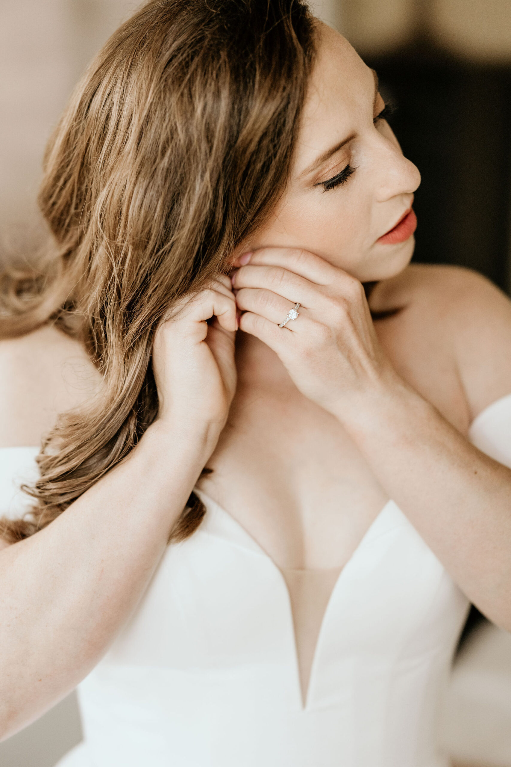 bride puts earring on for her mountain micro wedding in colorado.