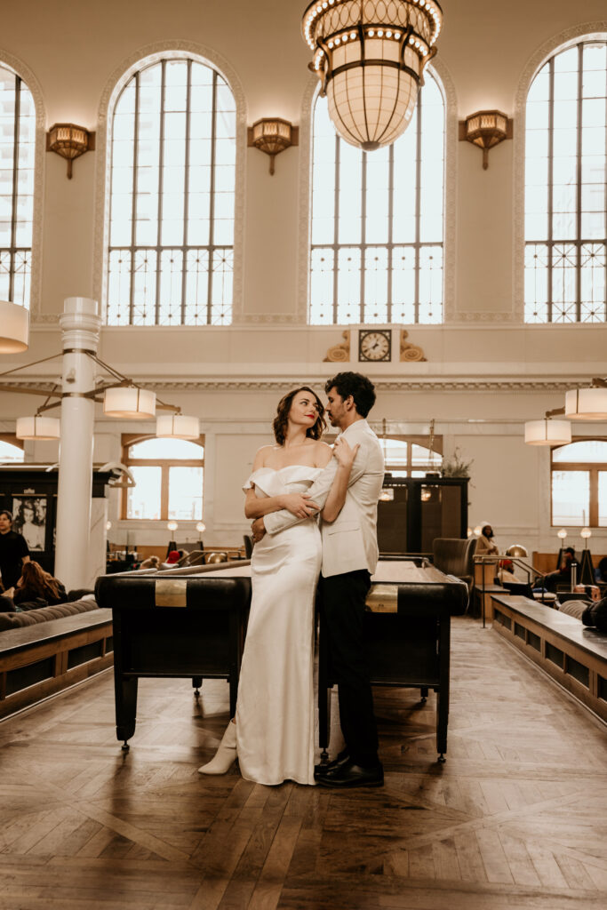 Bride and groom embrace in denvers union station during urban winter wedding in colorado.