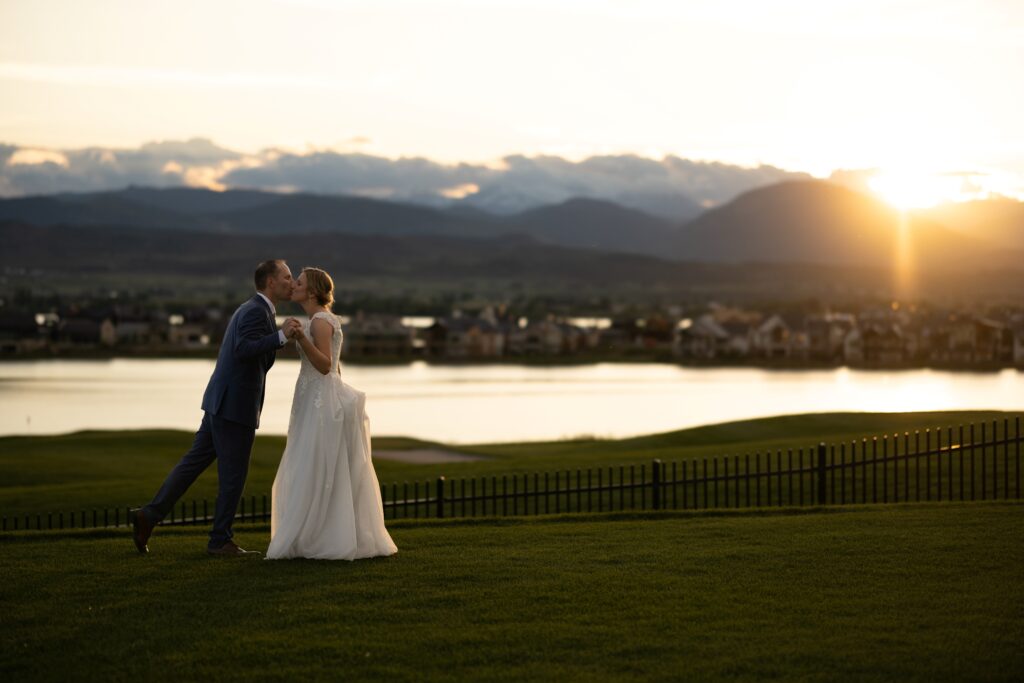 Bride and groom kiss with the colorado mountains in the background, during spring micro wedding.