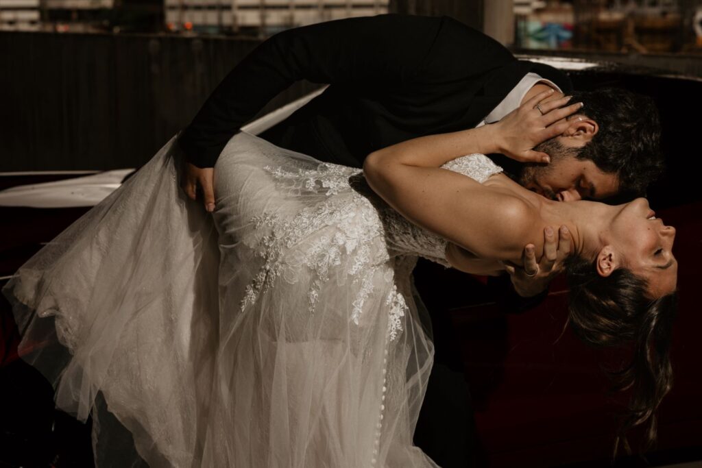 groom dips bride and kisses her neck during bridal portrait session in downtown denver.