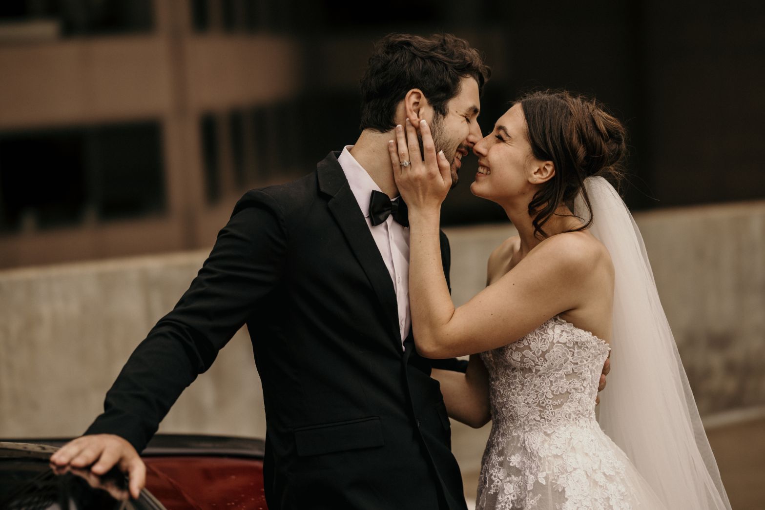 bride holds grooms face in her hands and smiles during bridal portrait session in denver colorado.