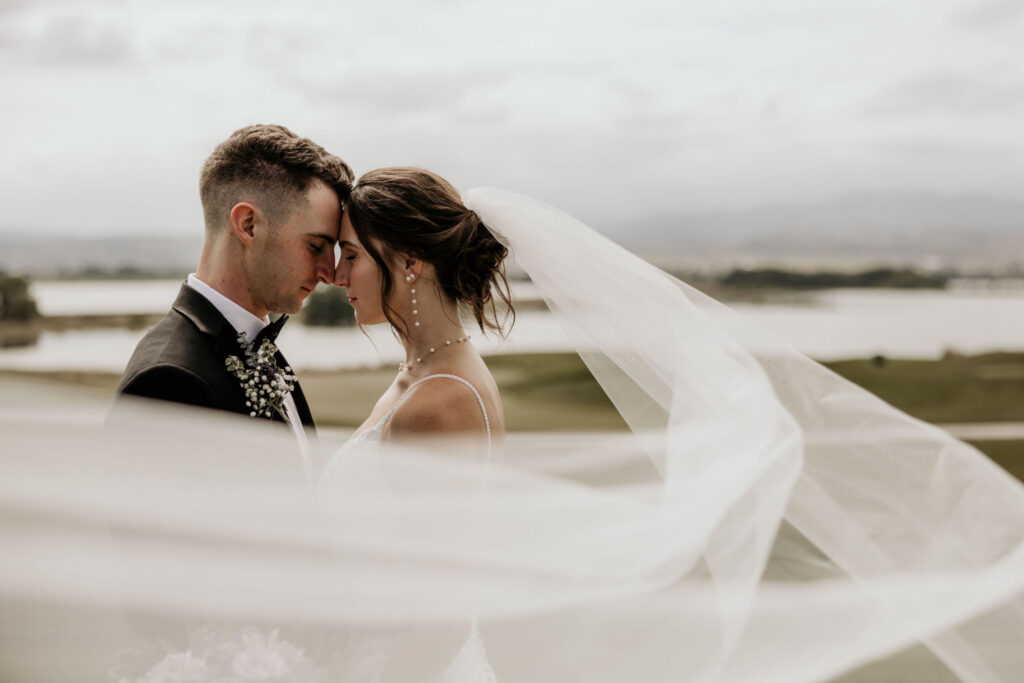 Bride and groom touch heads together during spring micro wedding in colorado.