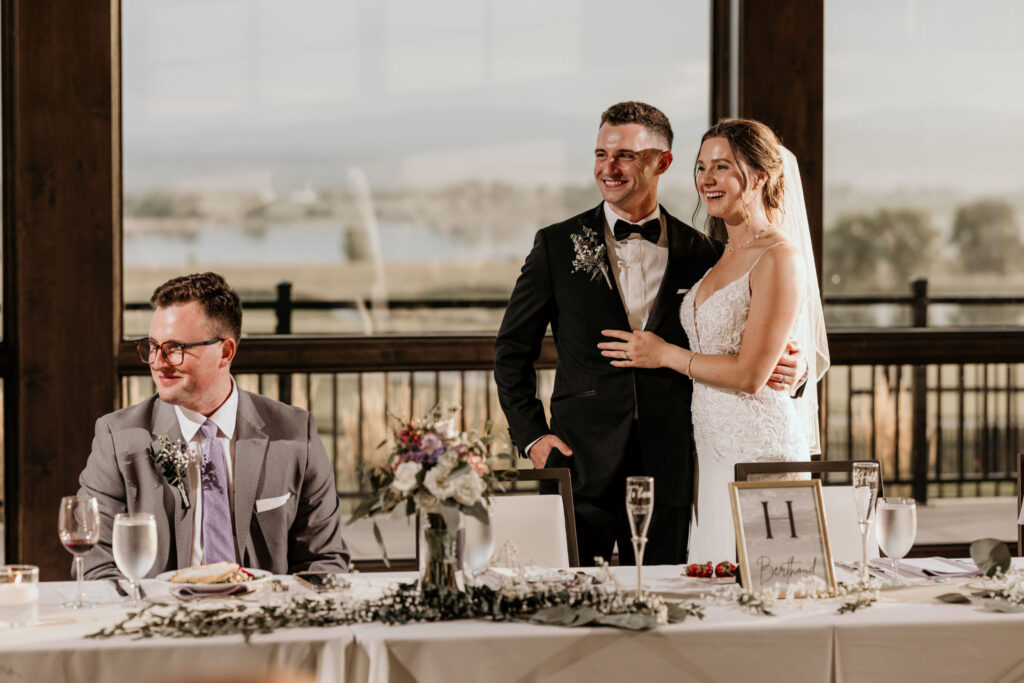 Bride and groom stand at head table during spring colorado wedding reception.