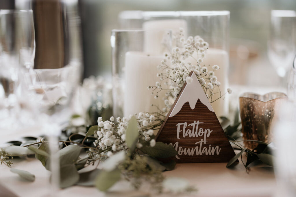 wooden mountain table topper sits on decorated table during colorado mountain wedding in estes park.