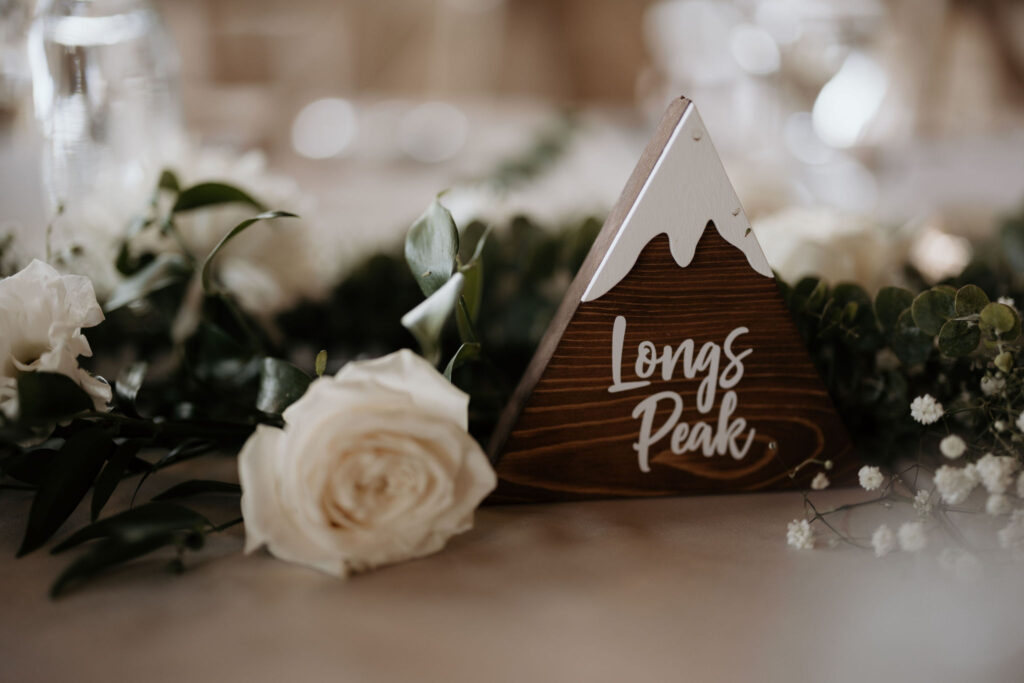 wooden mountain table topper sits on decorated table during colorado mountain wedding in estes park.