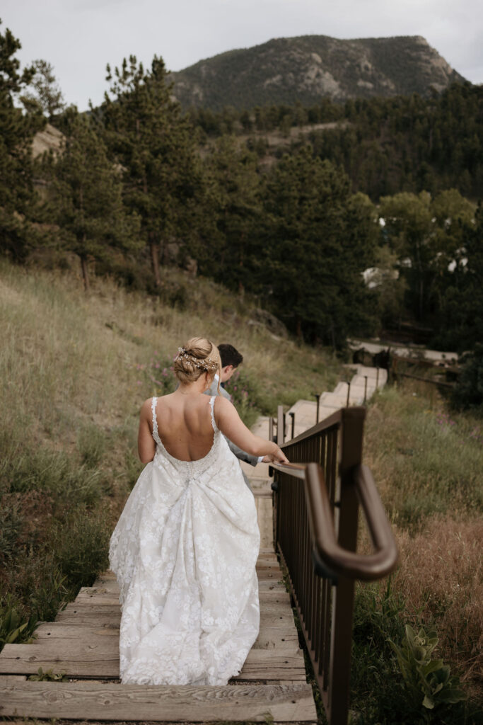 bride and groom walk down steps at skyview wedding venue in colorado.