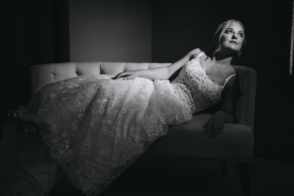 bride lays on couch and poses during bridal portraits for her colorado wedding in estes park.