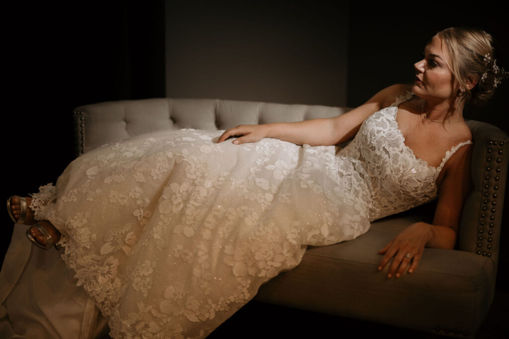 bride lays on couch and poses for bridal portraits at skyview in estes park.