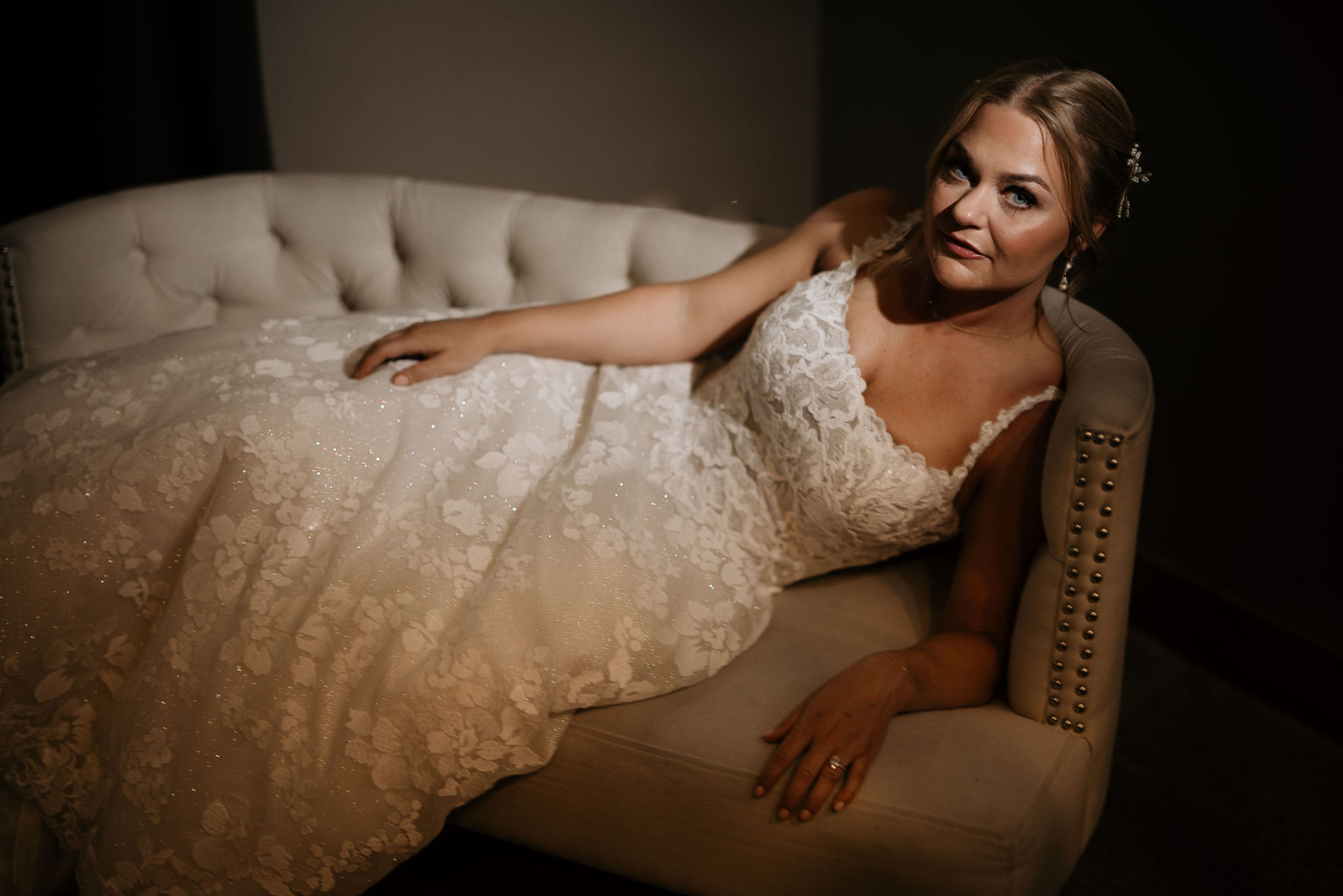 bride lays on couch and poses during bridal portraits for her colorado wedding in estes park.