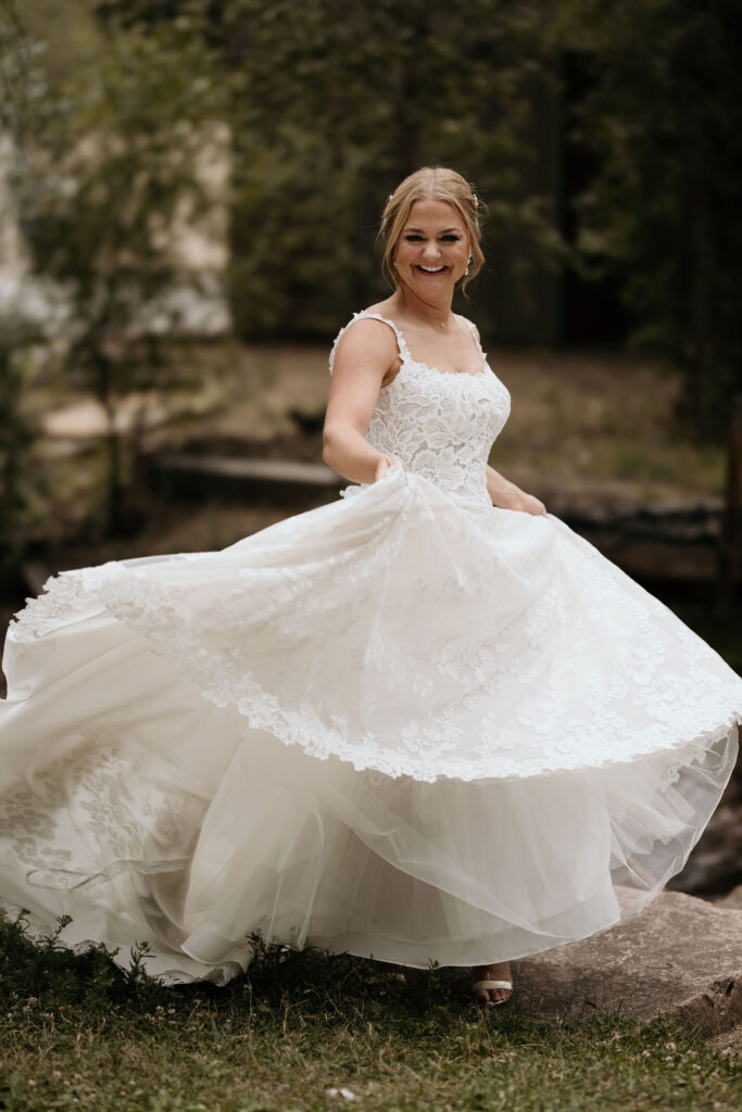 bride twirls her dress while taking bridal portraits at skyview wedding venue in estes park.