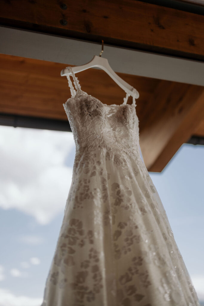 dress hangs outside of bridal suite at skyview in estes park during a colorado mountain wedding.