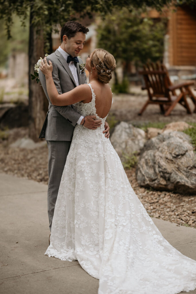 bride and groom hold each other and look at each other during their first look by the river at skyview venue.