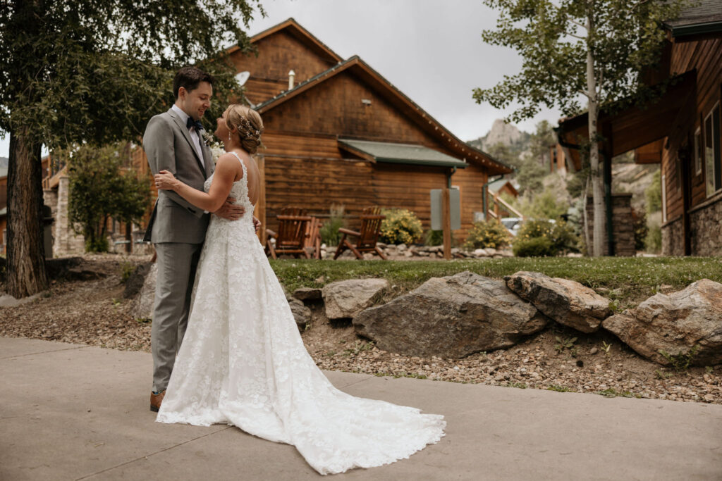 bride and groom stand close and embrace during bridal portraits at skyview wedding venue in estes park colorado.