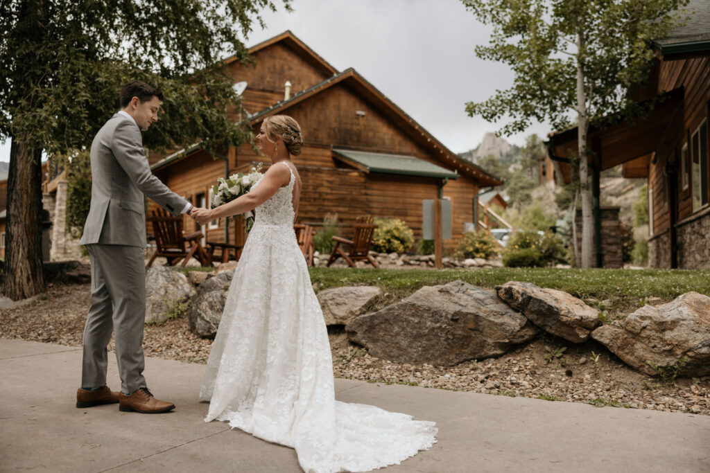 bride and groom face each other and hold hands during bridal portraits at skyview wedding venue in estes park colorado.