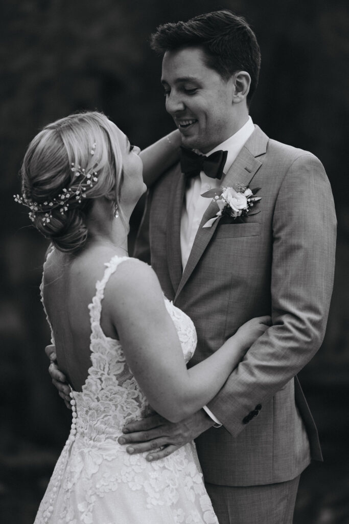 black and white image of bride and groom smiling during bridal portraits at skyview wedding venue.