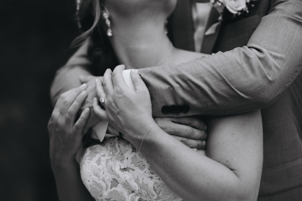 back and white close up image of groom wrapping arms around bride during bridal portraits in estes park.