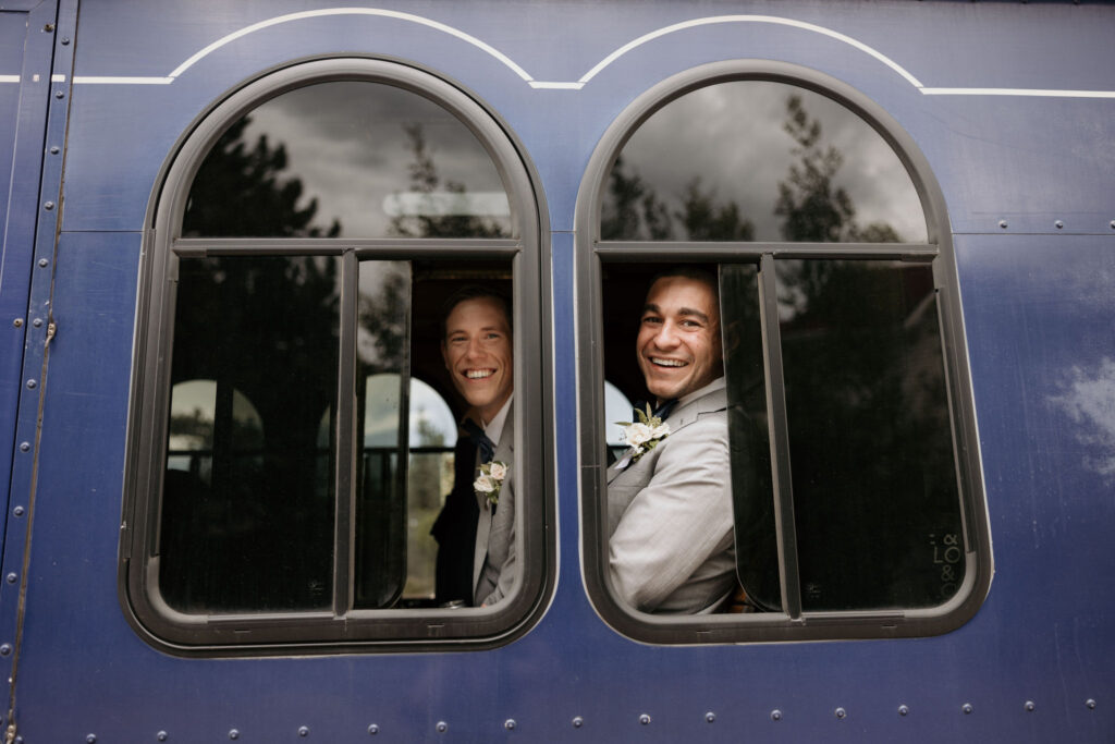 wedding guests smile out trolley window during sustainable wedding in colorado.