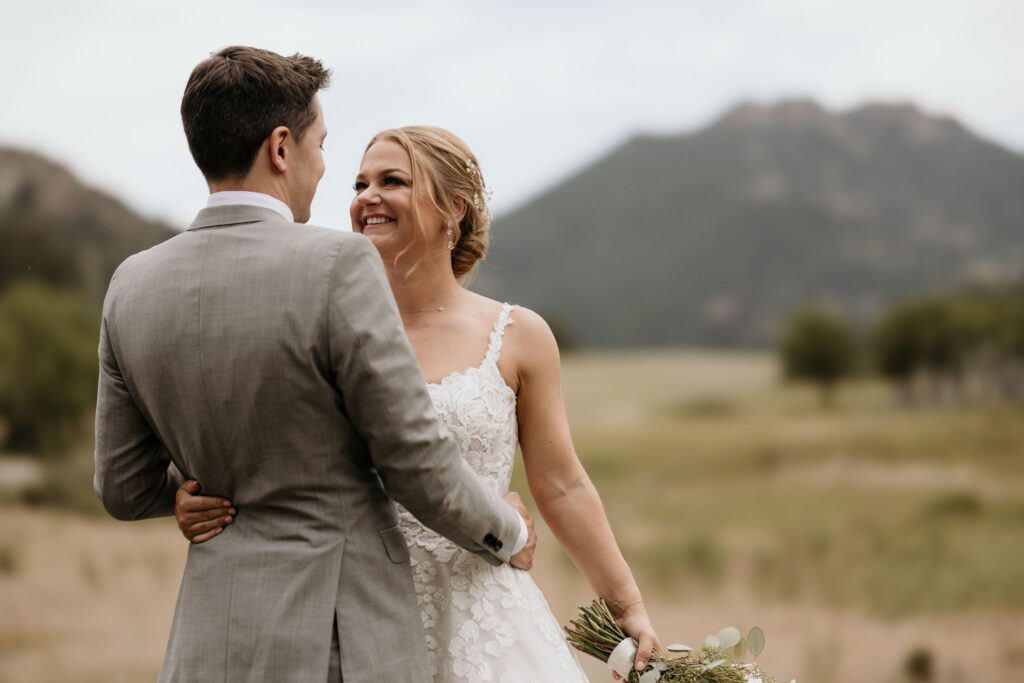 bride and groom look at each other and smile during wedding portraits at rocky mountain national park.