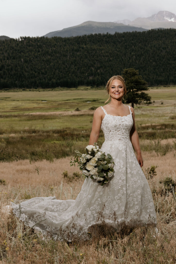 bride stands in front of rocky mountains during colorado wedding in estes park.