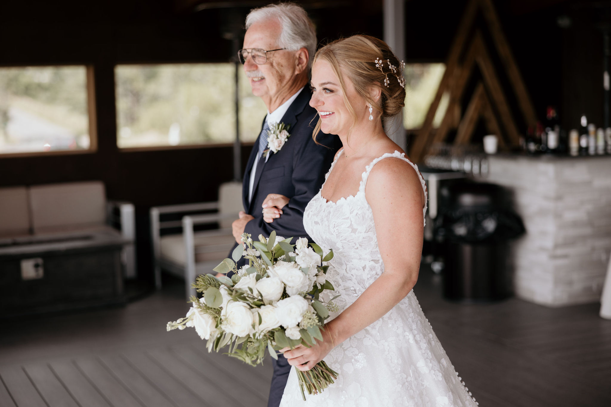 bride walks down the aisle with her dad at skyview wedding venue in colorado.