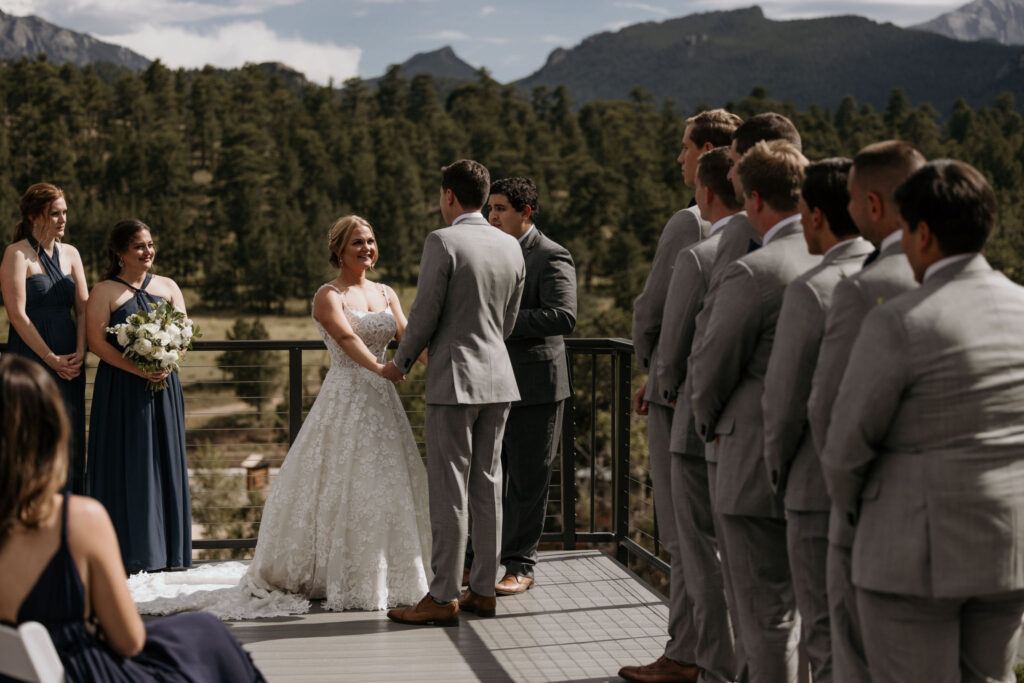 bride and groom, and wedding party stand up front at their colorado wedding ceremony at skyview venue.