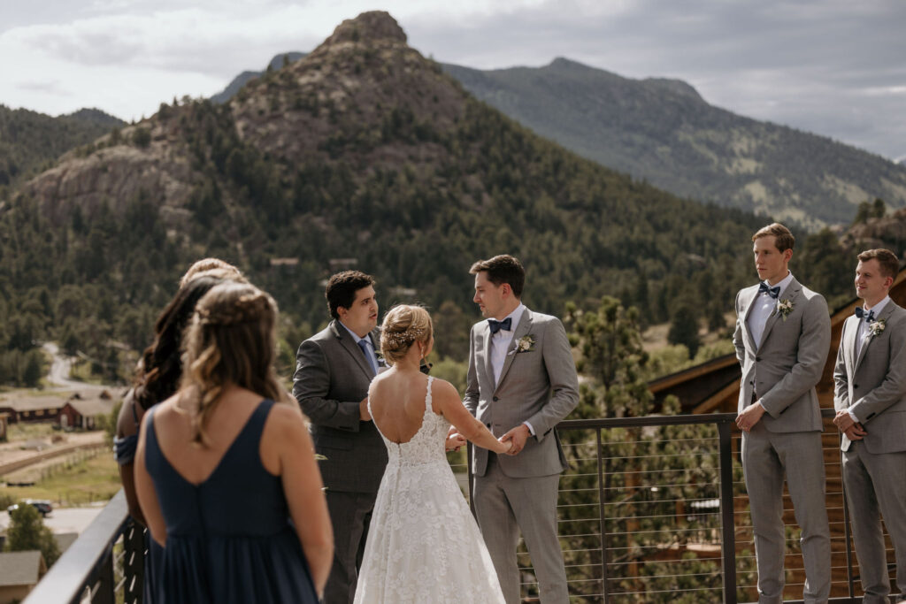 bride and groom, and wedding party stand up front at their colorado micro wedding ceremony in the summer.