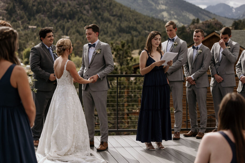 bride, groom, and wedding party stand up front and listen to speech at their colorado wedding ceremony at skyview venue.