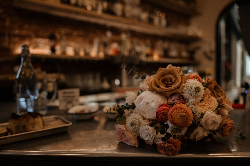 wedding florals sit on the bar during downtown denver wedding reception.